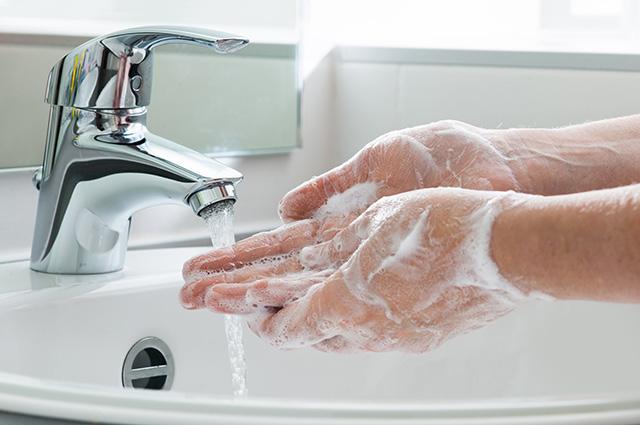 A person washing their hands with soap and water
