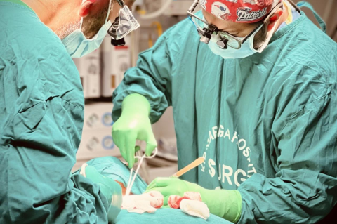 Otolaryngologists Ameer Shah (in the Patriots cap), A07, M13, and Jagdish Dhingra, both faculty at Tufts University School of Medicine, performed surgery on a patient in Rwanda.